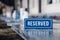 Closeup wooden blue white rectangular plate with the word Reserved standing on gray table in restaurant. Ð¡oncept of preparation