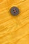 Closeup of wooden button on yellow organic cotton