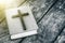 Closeup of wooden Christian cross on bible on the old table