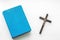Closeup of wooden christian cross and bible on the white background.