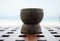 Closeup of wooden cup on wooden table with beach in background