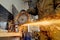 Closeup of worker using a grinder cuts metal in a workshop