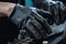 Closeup of workers hands in black gloves working on car engine, A closeup view of factory laborer hands in action, AI Generated