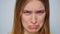 Closeup worried woman looking at camera on grey background in studio.