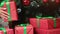 Closeup wrapped red gift boxes woman hands putting under Christmas tree. 4k Dragon RED camera