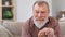 Closeup wrinkled face of crying disabled grandfather suffering stress depression at retirement house