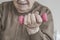 Closeup wrinkled hand of a senior person holding dumbbell