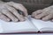 Closeup wrinkled hands of a person holding a pen