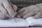 Closeup wrinkled hands of a person writing