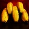 Closeup of yellow bananas bunch like fingers on red bloody background