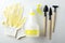 Closeup of yellow gardening gloves, water sprayer and plant tools on the white surface