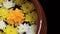 Closeup yellow marigold flower with white and yellow dandelions floating on the water with the edge of pottery water.