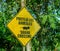 Closeup of a yellow [proteja los animales] - protect animals - and iguana crossing sign on the road