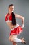 Closeup young active brunette woman in red cheerleader costume poses for photo