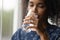Closeup of young african woman drinking cool water from glass