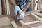 Closeup young asian carpenter polishing wooden job with sanding machine