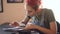 Closeup of young attractive red haired woman tattoo artist sitting at table and creating sketch for tattooing in studio