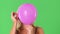 Closeup of young blonde woman and pink helium balloon popping