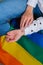 Closeup of young caucasian millennial hippie woman with a rainbow flag in heart shape painted in wrist. Rainbow color