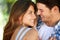 Closeup of a young couple loving in the park, and standing in the summer sun under the tree. Cheerful, bonding outdoor