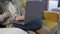 Closeup young couple sitting on the couch, a man typing on a laptop, a woman pointing at a laptop screen