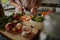 Closeup of young female hands chopping fresh vegetables on chopping board while in modern kitchen - preparing a healthy