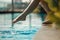 Closeup young female leg make splash of blue water in swimming pool