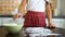 Closeup young girl hands preparing working surface for dough kneading spreading flour on dark table