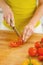 Closeup on young housewife cutting tomato on cutting board