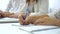 Closeup young male and female student hands writing with pens in notebook in classroom