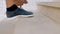 Closeup of young man`s hand fastening shoelaces of gray running shoes