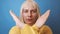 Closeup of a young sad caucasian 30s woman wearing yellow sweater crossing hands makes stop gesture look camera isolated