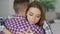 Closeup of young upset couple embrace each other after quarrel. Woman looking wistful and sad hug her boyfrined at home