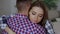 Closeup of young upset couple embrace each other after quarrel. Woman looking wistful and sad hug her boyfrined at home