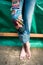 Closeup of young woman barefoot legs in boho style jeans with co