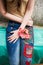 Closeup of young woman in boho style blue jeans with colorful ap