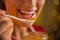 Closeup on young woman eating homemade orange jam
