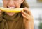 Closeup on young woman eating melon in kitchen