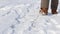 Closeup of young woman feet walking through the fresh snow. Snowfall in winter in the forest