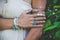 closeup of young woman hand and arm with lot of boho style jewrly, rings and bracelets outdoor shot