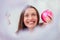 Closeup of young woman holding a pink bauble for the Christmas tree, showing off what nice toys she has bought for this