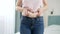 CLoseup of young woman in jeans holding fat fold on her belly. Concept of excessive weight, obese female, dieting and