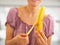 Closeup on young woman peeling banana