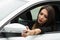 Closeup young woman sitting in car adjusting side mirror, as seen from outside drivers window, female driver concept