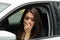 Closeup young woman sitting in car interacting using body language, as seen from outside drivers window, female driver