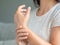 Closeup young woman sitting on sofa holds her wrist. hand injury