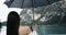 Closeup young woman stay with her back and naked shoulder to camera under her black umbrella and are looking to amazing