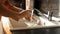 Closeup of young woman washing dishes in kitchen sink. Housewife working, domestic chores, doing housework