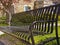 Closup of empty black iron bench in local church park