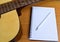Closup Guitar and Blank notepad with pencil